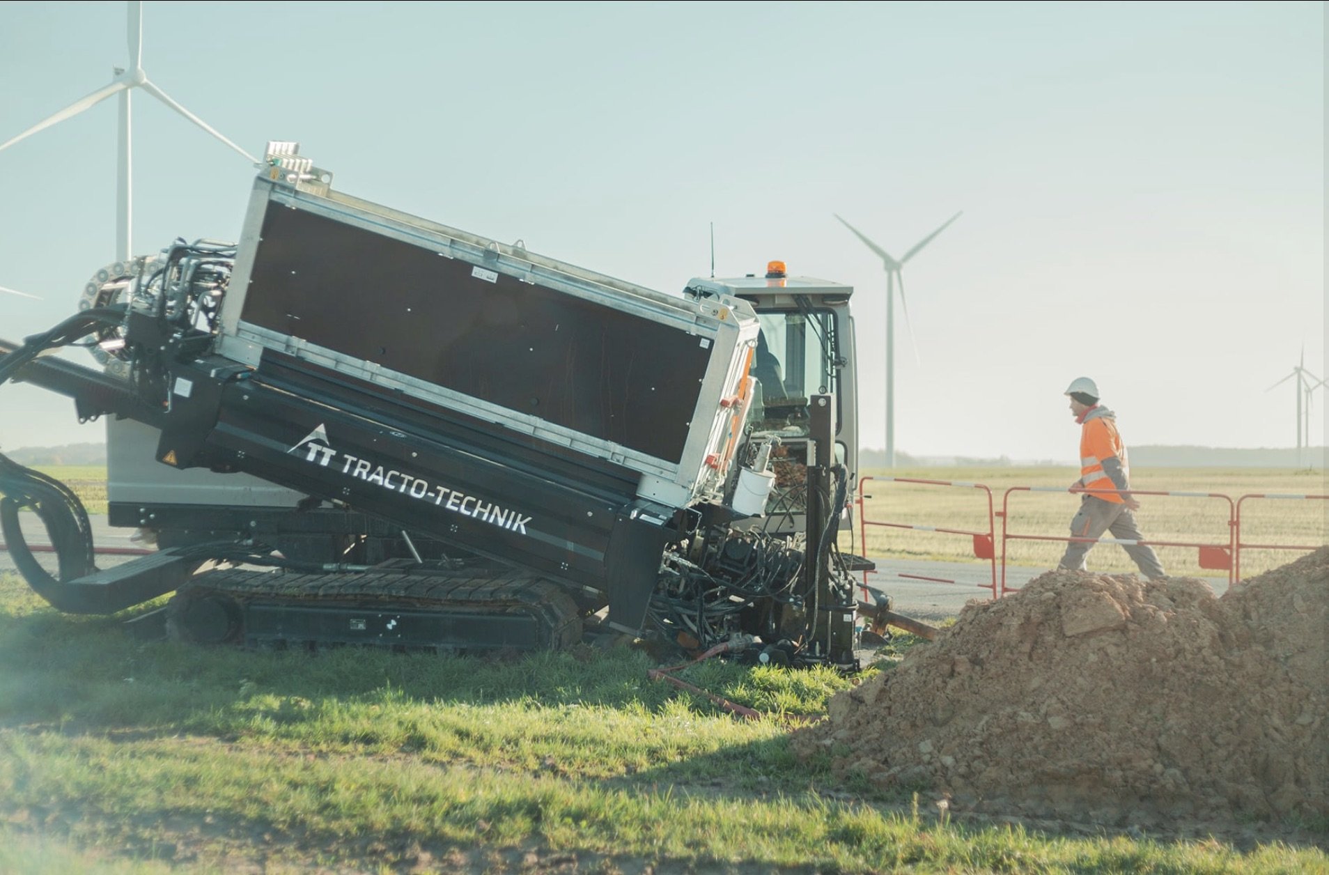 Foreuse Tracto-Technik sur chantier avec éoliennes en arrière-plan